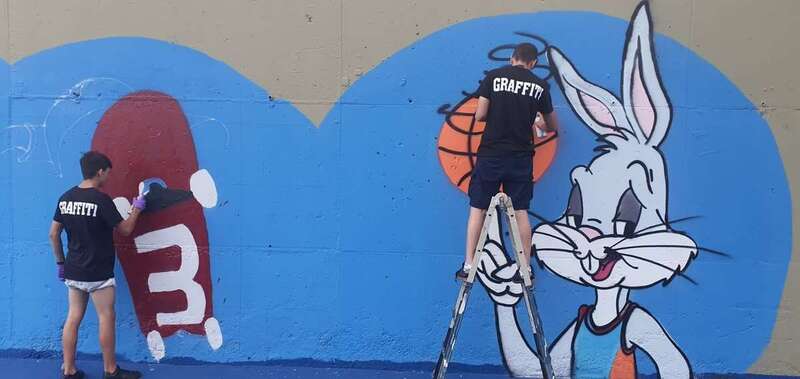 Dos jóvenes pintan un grafiti en la cancha de El Dorado / TA